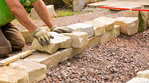 Eine Mauer aus Naturstein wird errichtet 